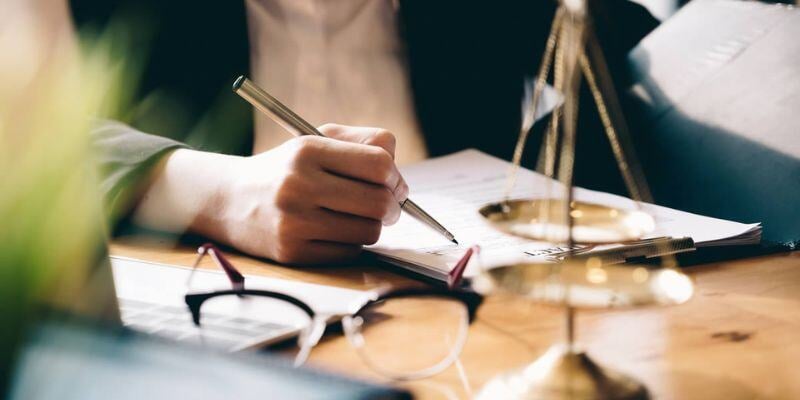 A lawyer sitting at their desk filling in paperwork.
