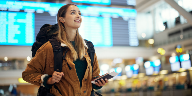 Woman in airport with passport, ready to board a flight.